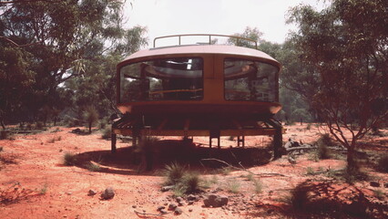 A striking modern home features large glass windows and a circular design, elevated above the red earth, surrounded by lush greenery and unique Australian bushland.