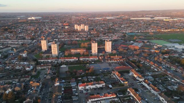 Aerial establishing shot of Enfield, UK, neighborhood at sunset, houses and apartment blocks