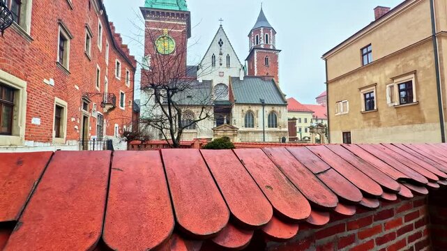 Brick rooftop parapet at Wawel Royal Castle in Krakow, Poland, with cathedral towers in misty weather&mdash;great for travel, history, architecture (editorial).