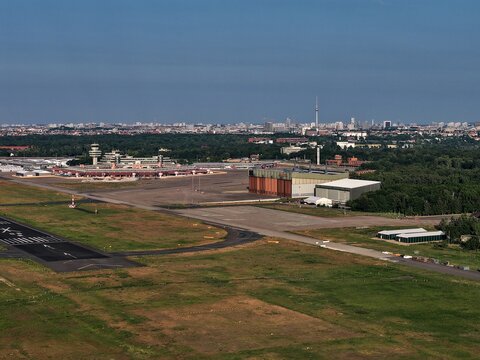 Aerial view of the sprawling Tegel Airport, its control tower standing tall amidst the cityscape, the runways, hangars, and green spaces, Berlin, Berlin, Germany.