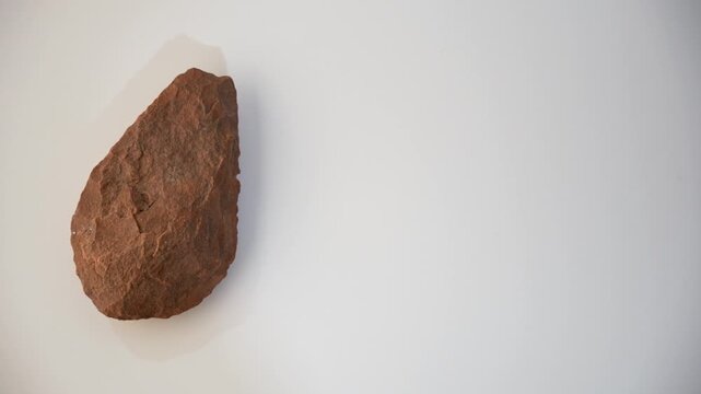 Prehistoric stone point. Spear. White background. Lower Paleolithic. Homo heidelbergensis. Hunting, super slow motion video at 100 fps