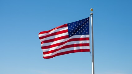Obraz premium American flag against a clear blue sky symbolizing patriotism