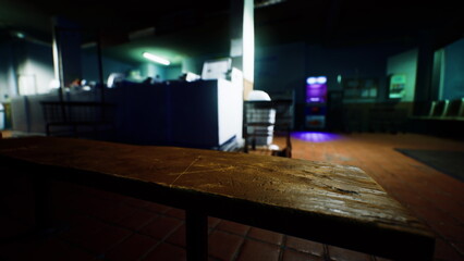 A rustic wooden bench stands in focus as soft light filters through a quiet room. Faded blue walls and faint shadows create a calm atmosphere, inviting reflection and peace.