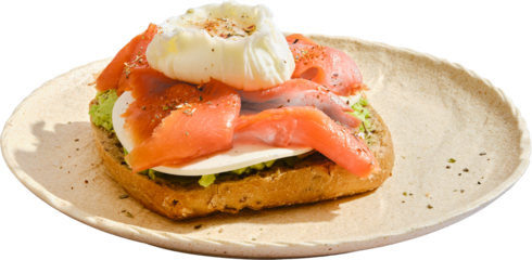 Delicious breakfast flatbread topped with poached egg and smoked salmon served on a plate