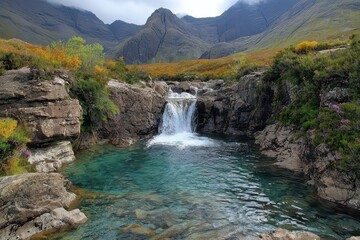 Serene Andean Waterfall Flowing into Clear Turquoise Pool Surrounded by Rocky Outcrops and Colorful Flora in a Mountainous Landscape under Cloudy Sky