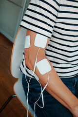 a man using a muscle stimulation device on his arm