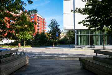 Daylight cityscape of modern urban plaza with walkway and trees showing architecture design shaping open public space with clean lines