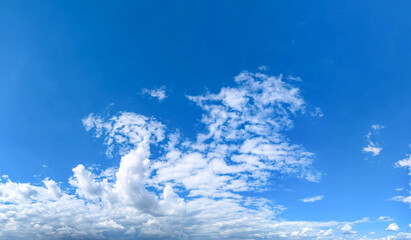 A raster image of a some cloud photographed against a blue sky. Easy relaxed cottony shape. Background quiet sky. Fiber contours after rain. Lonely free substance water. Copy space for text.