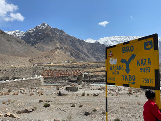 Obraz premium Road sign near Tabo pointing towards Kaza and Nadan in the mountains of Himachal Pradesh during a sunny day