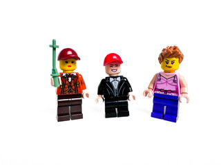 Obraz premium Three Colorful Lego Mini Figures in Various Attires with Accessories