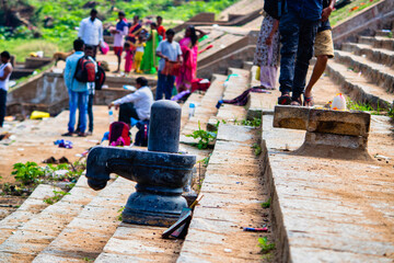 Obraz premium People gather at a riverbank with stairs and a water source during a sunny day for social activities and relaxation