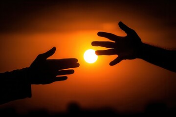 Silhouetted hands reaching out to each other with the bright sun between them in a warm orange sky