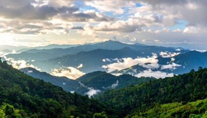 Fototapeta premium A panoramic view of lush mountains under a dramatic, cloudy sky with valleys shrouded in mist