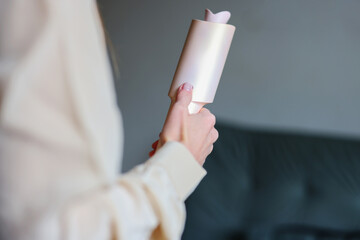 Close up of woman holding modern hair styling tool at home representing beauty routine self care and everyday lifestyle