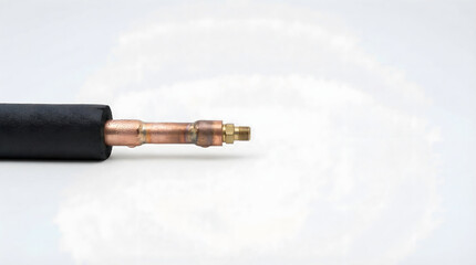 Close-up of black hose with copper fitting