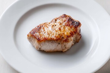 Grilled pork chop on white ceramic plate close-up