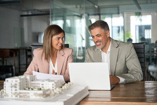 Real estate developers working on laptop discussing new residential or commercial development construction project at meeting. Investing in realty, bank mortgage loan concept.