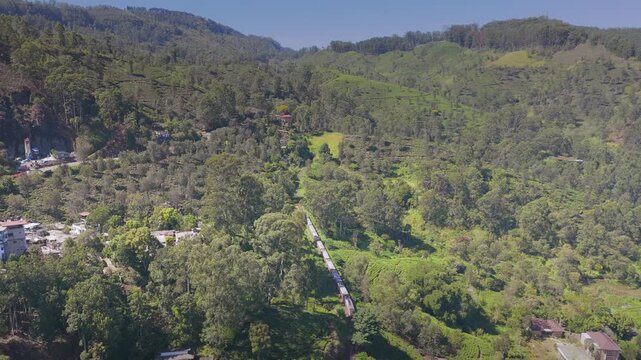 Drone Tracking Shot of Train Entering Tunnel Through Green Hills