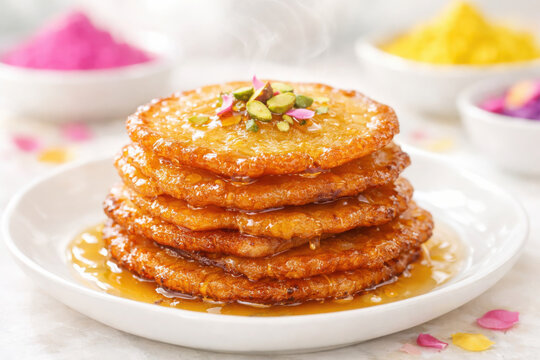 malpua pancakes served during Holi stacked golden sweet pancakes soaked in syrup