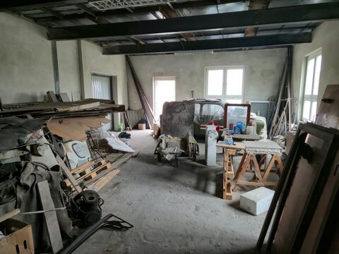 Empty Industrial Space Filled with Rubble and Pallets