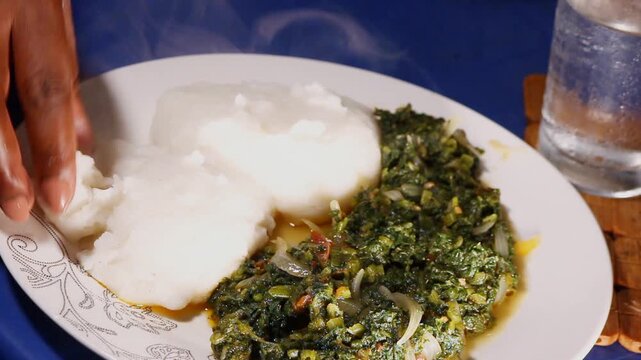 Plate of African Pap Sadza with Pumpkin Leaves Stew Known as Muboora or Ugu, Traditional Maize Meal Dish