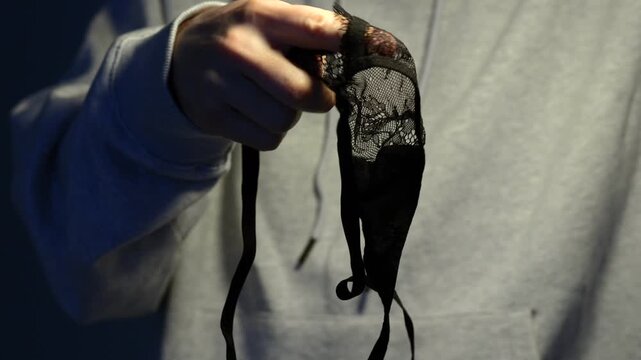 Sexy black lace panties in a man's hands.
Sheer women's thong.
Sexy and exciting lingerie for role-playing.