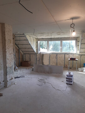 installation of a plasterboard ceiling. plaster is glued with paper and screwed to metal profiles with ceiling and wall screws in the attic. joints are also plastered with plaster, wires to chandelier