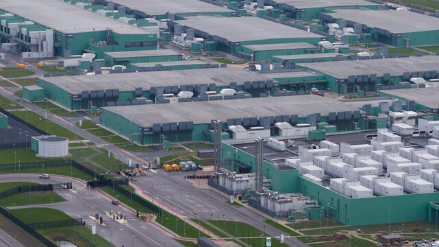 Aerial view of the sprawling AI Data Center complex, a symphony of green and grey, dominates the landscape, Agriport, Middenmeer, Netherlands.