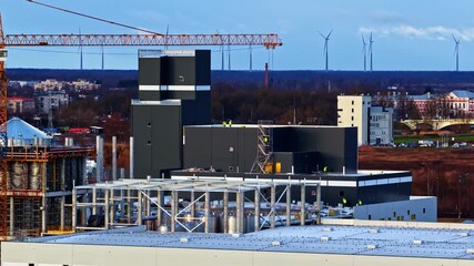 Industrial landscape with wind turbines and cranes; calm and productive scene