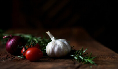 A fresh and healthy organic still life of raw garlic, red tomatoes, and ripe onions creates a vibrant vegetarian food ingredient composition for festive kitchen cooking on a white background
