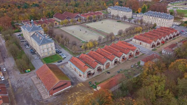 Aerial drone view of the Garde R&eacute;publicaine's Quartier Carnot, showing stables and training grounds. Horses are being ridden in the arenas. Ideal for equestrian and military concepts, France