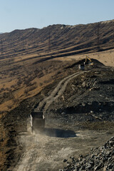 Dump Truck and Excavator at Mountain Road Construction Site