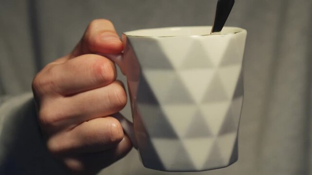 A man holds a white ceramic cup.
A hot drink in a beautiful, stylish cup.
Cup, drink, water, liquid