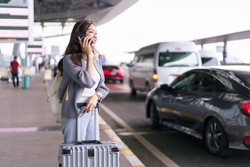 Asian woman traveler talking on smartphone at airport terminal