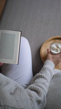 woman reading a book on a sofa and drinking coffee, morning routine, self care