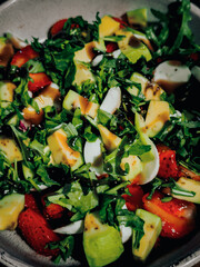 Hand holding fork vegetable salad with lettuce, olives and feta cheese on yellow background. Fresh and natural healthy food concept for banner advertising or menu layout. Top view. High quality photo