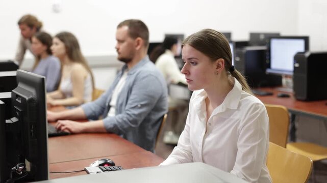  Young woman using computer for work in office with colleagues