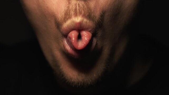A man who has cowered aggressively moves his tongue.
An indecent tongue gesture.
A man teases and sticks out his tongue at the camera.