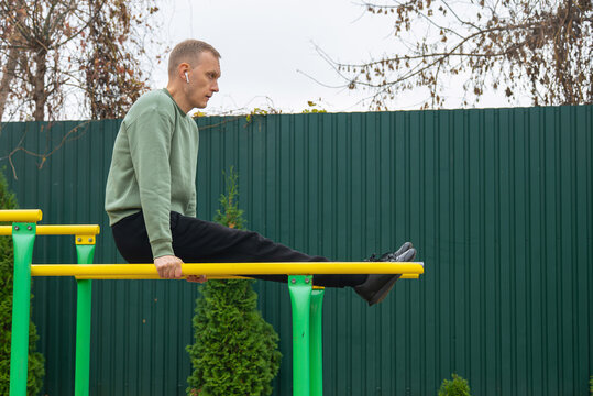 Man exercising on parallel bars outdoors