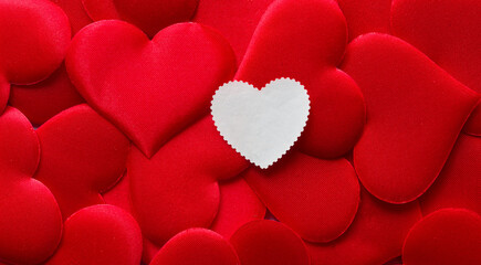 Creative mockup for wedding invitation or romantic note. Clean white paper label in heart shape with copy space lying on bright red silk texture. Vintage mail concept. Photo