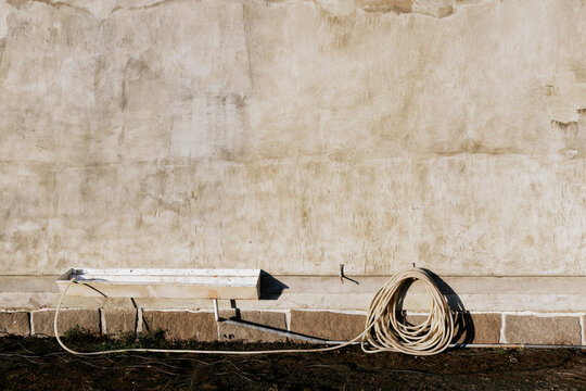 Exterior wall with coiled hose lying on the ground