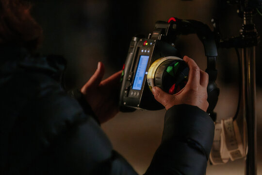 Cinematographer adjusting camera focus settings during shoot