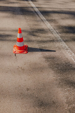 Orange traffic cone on asphalt road with white line