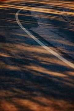 Winding road with sunlight and shadows