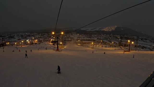 Night skiing at a mountain resort with lighted slopes and lifts