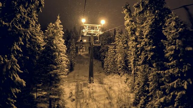 Night ski lift ride in snowy forest