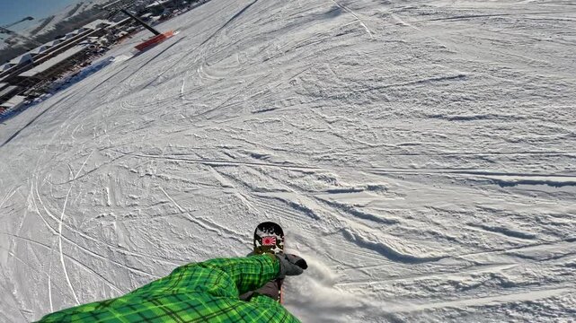 Snowboarding at a ski resort during a sunny winter day with panoramic views