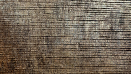 Close-up of a weathered, rough, unplaned wooden board surface used as a background texture. 