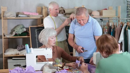 Group of senior learners enjoying sewing class in workshop