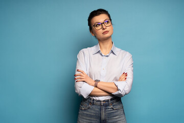 Successful employee pensive business woman, lost in thought and conjectures isolated on blue background